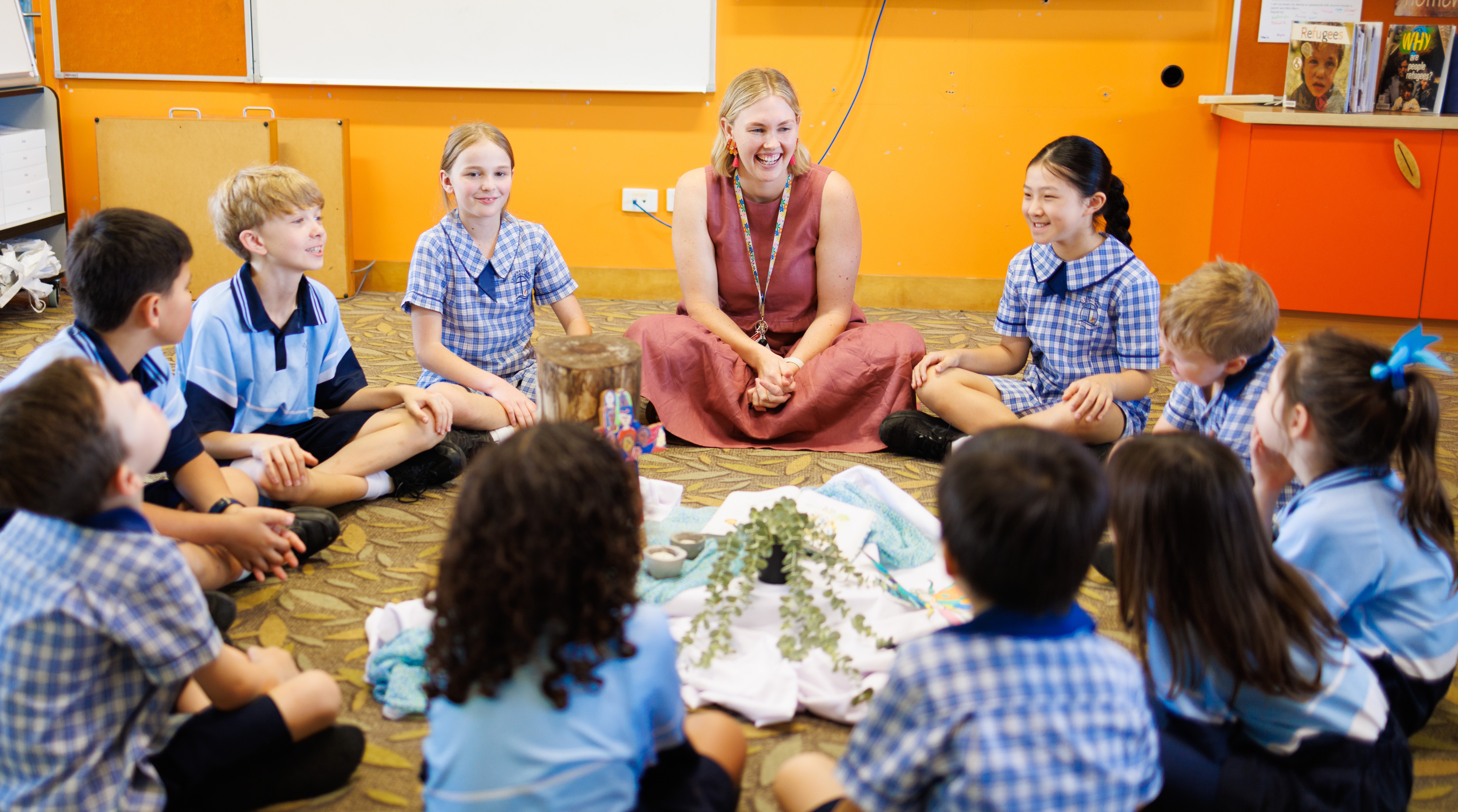 Students sitting in a prayer circle with a teacher