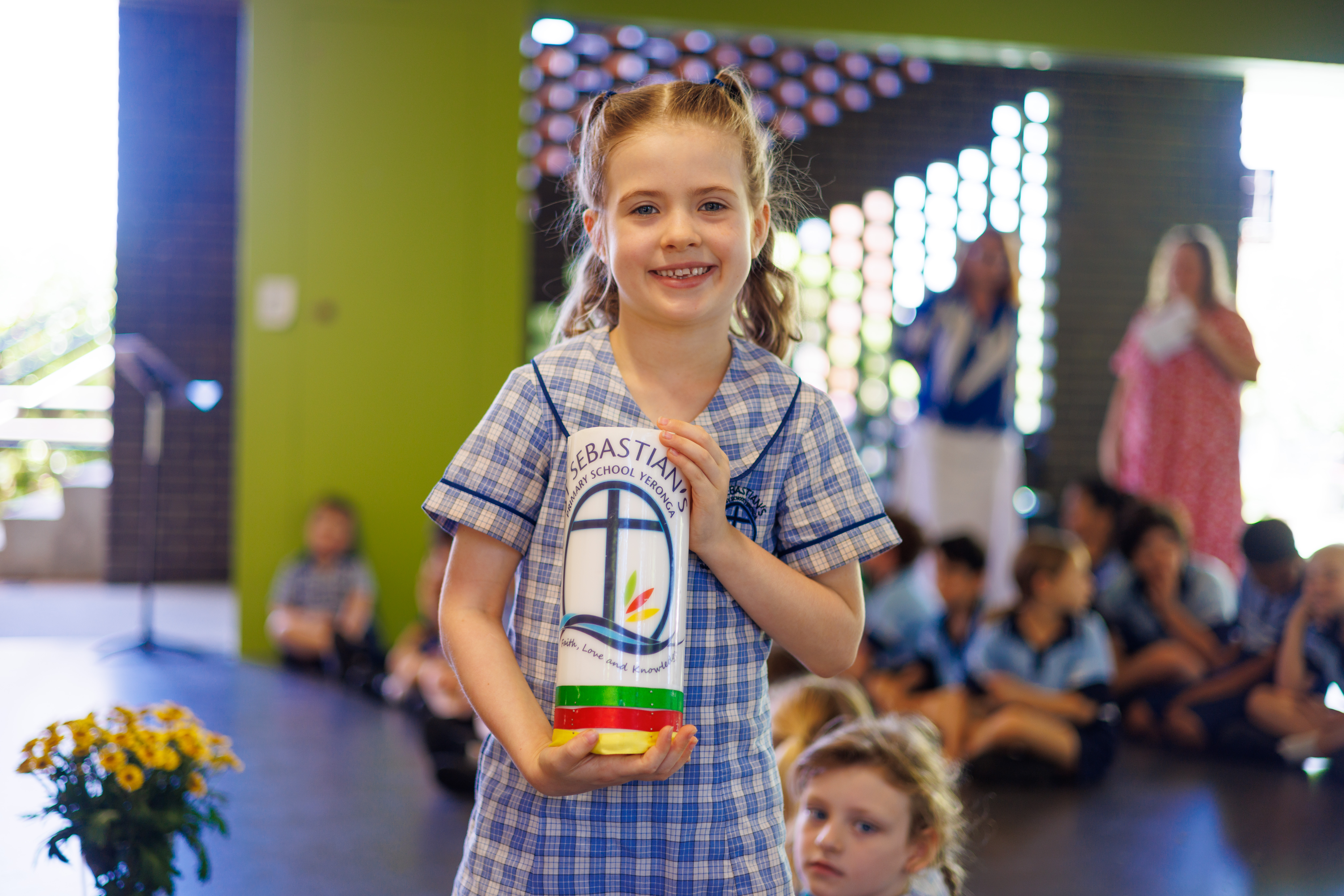 A female student carrying the St Sebastian's candle